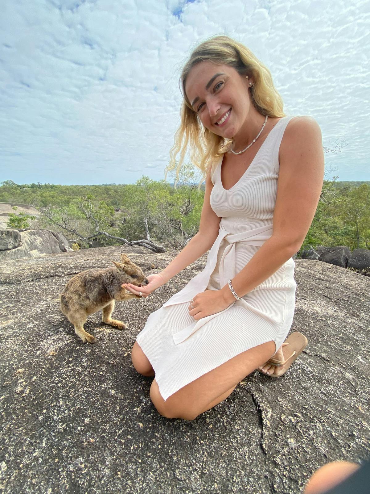 Girl enjoys the experience of hand feeding the unadorned rock wallaby at Granite Gorge