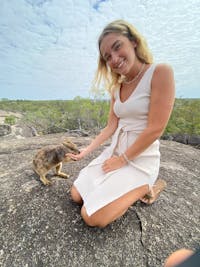 Girl enjoys the experience of hand feeding the unadorned rock wallaby at Granite Gorge