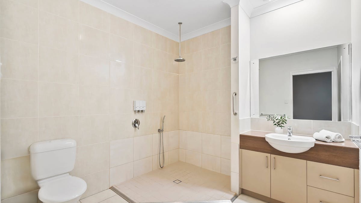 The clean, modern bathroom at the Emerald Inn with a rain shower and step through shower.