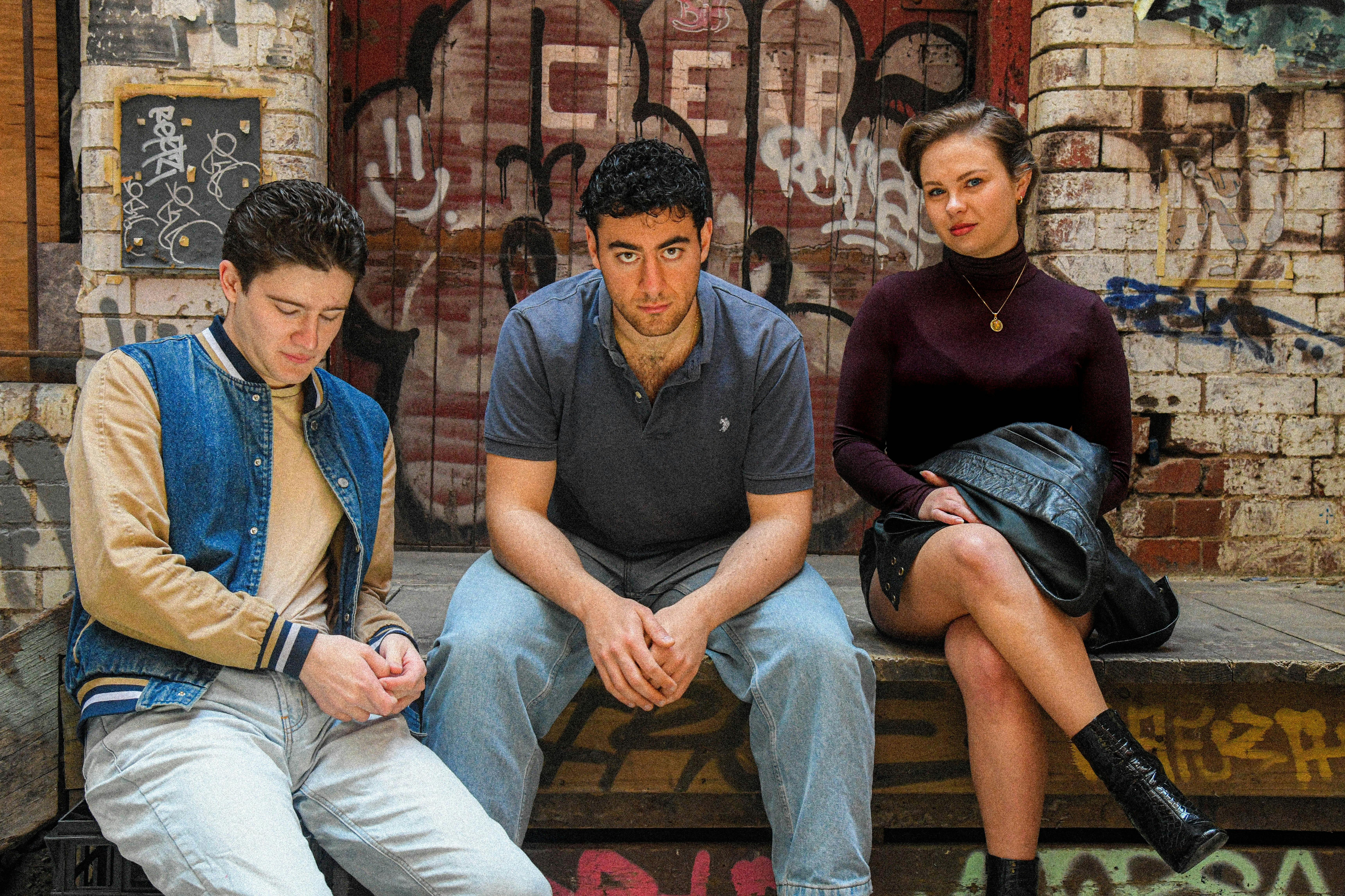 Three youthful people look directly at the camera