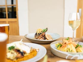 A spread of food and drinks on an outdoor table at The Bushmanu2019s Arms Hotel.