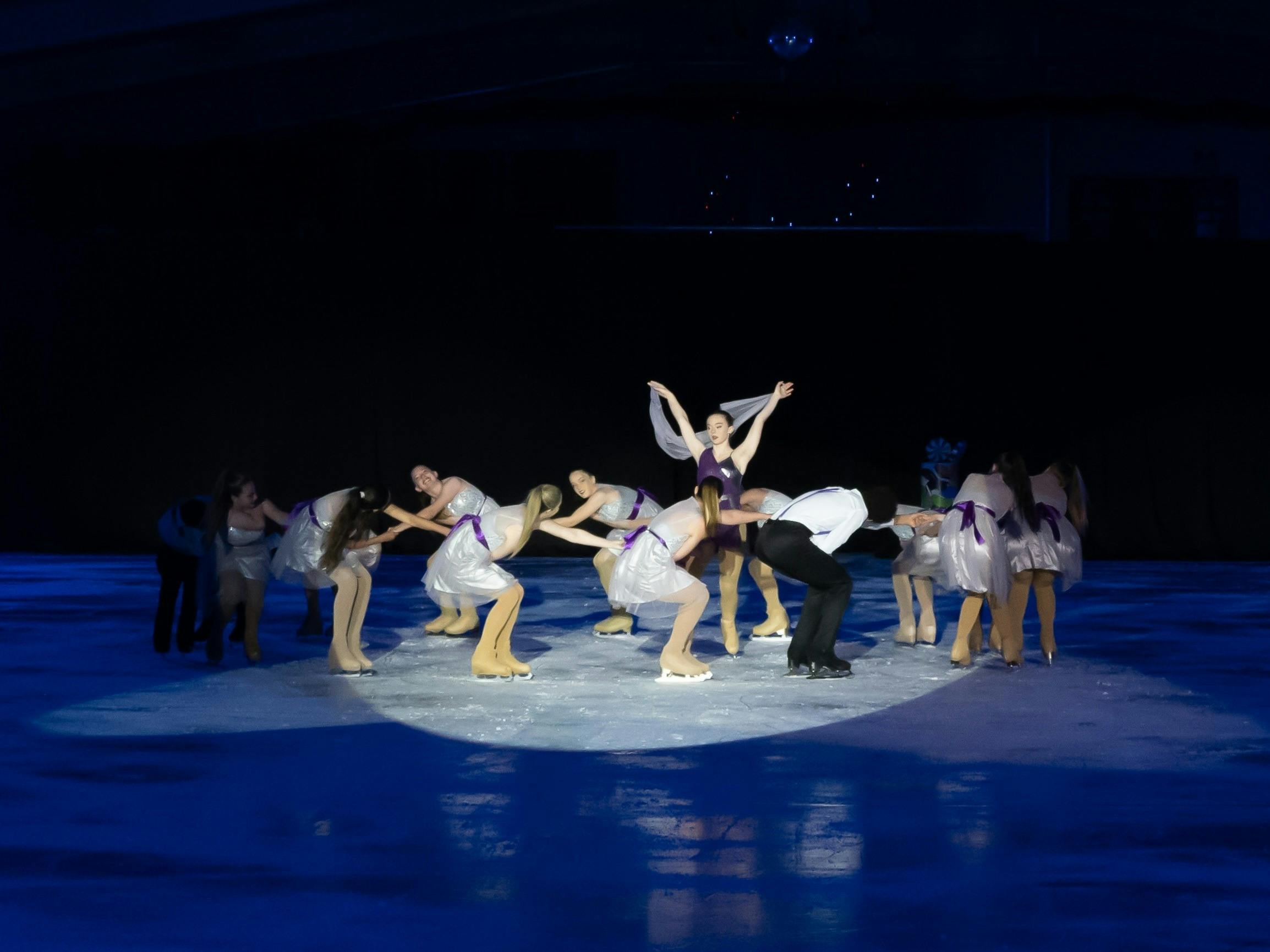 Figure skaters in silver and purple costumes