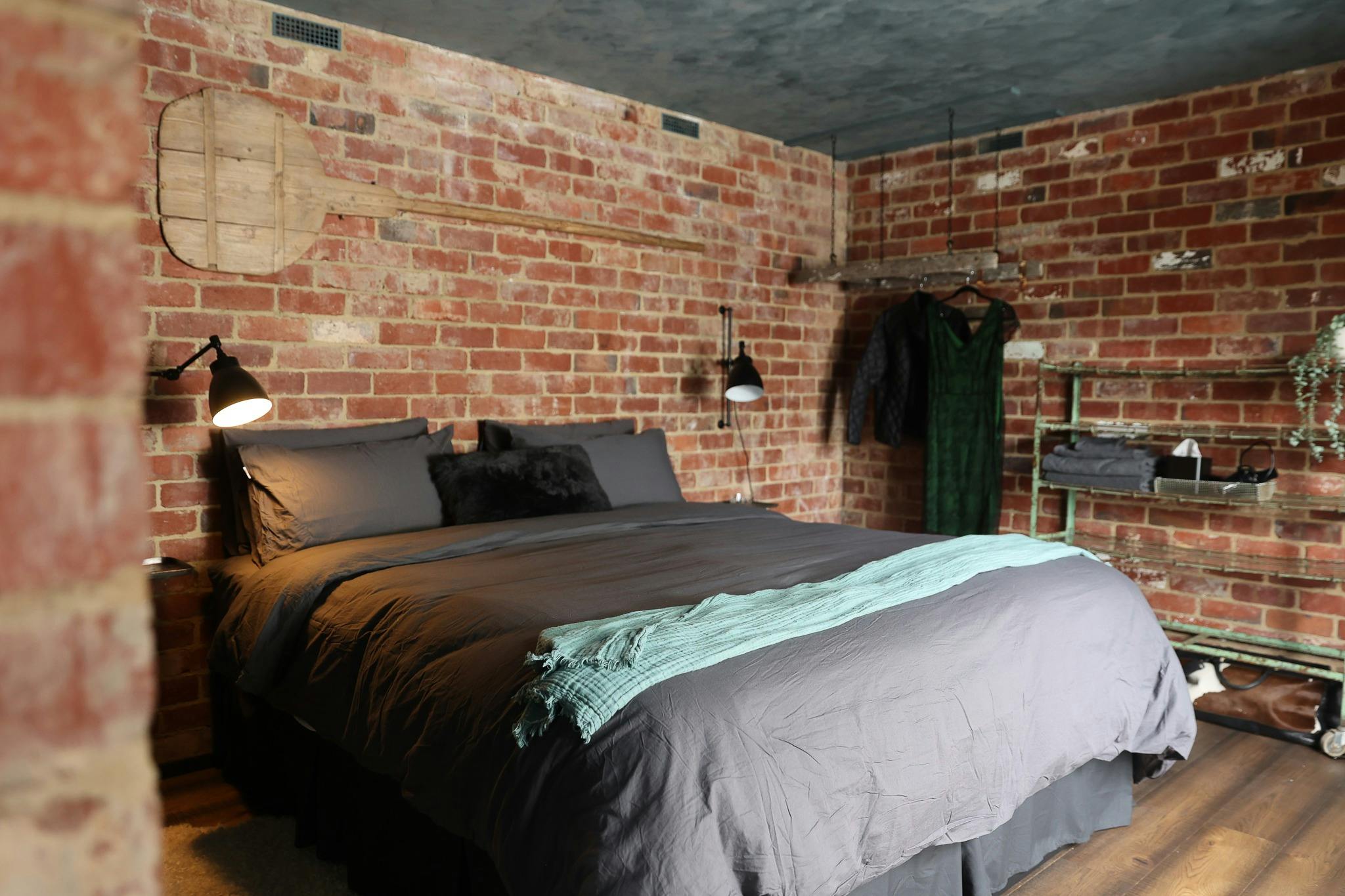 Bedroom with brick walls contains king size bed