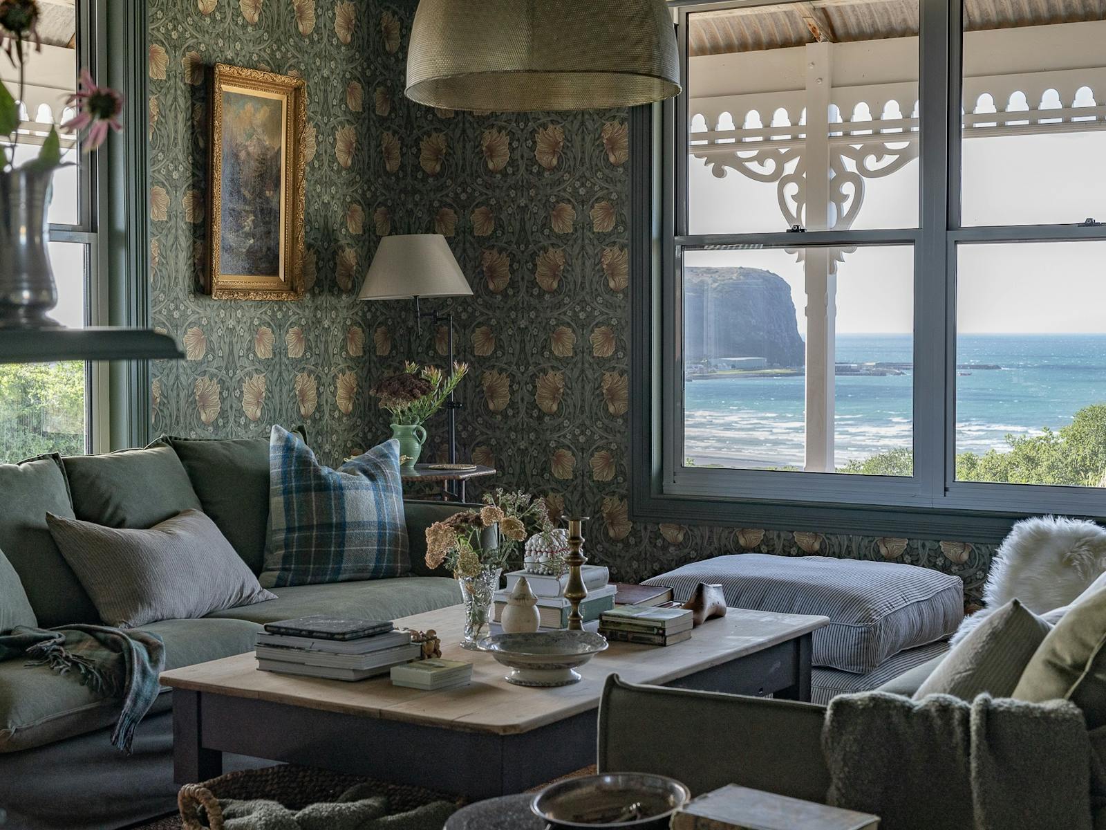 Lounge room with deep green floral wallpaper,  sneak peak of the Stanley Nut through the window.