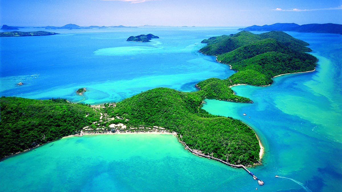 Aerial view of the lenghty strech of Long Island surrounded by coral reef and calm waters