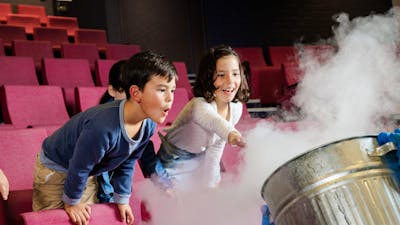 Two children participating in a science show using liquid nitrogen at Questacon