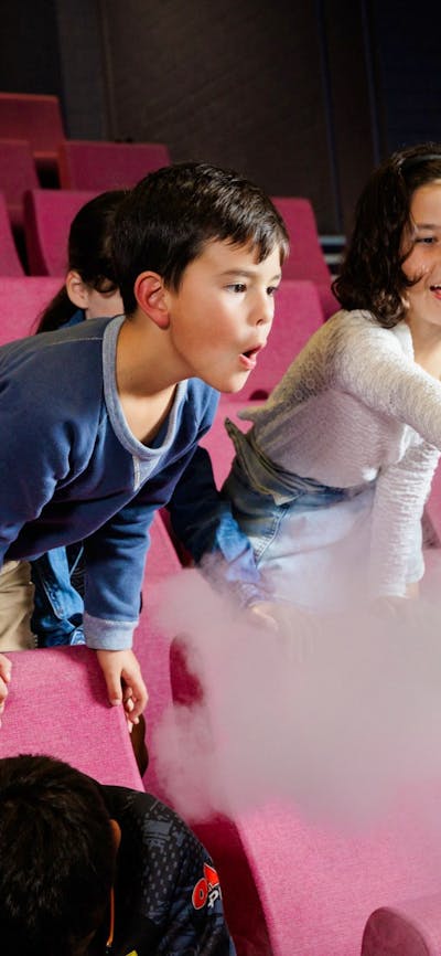 Two children participating in a science show using liquid nitrogen at Questacon