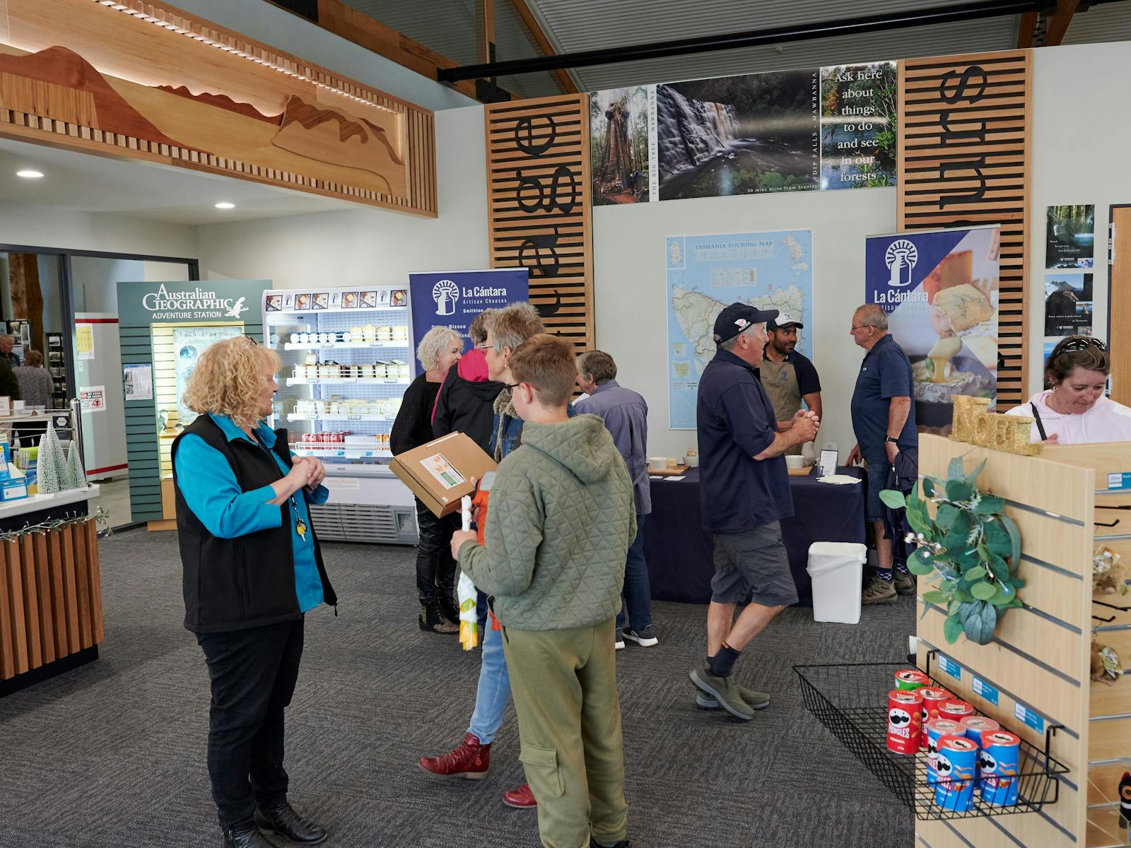 People in the Smithton Visitor Information Centre talking and doing a cheese tasting.