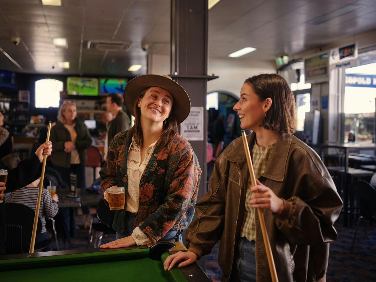 two girls playing pool at pub