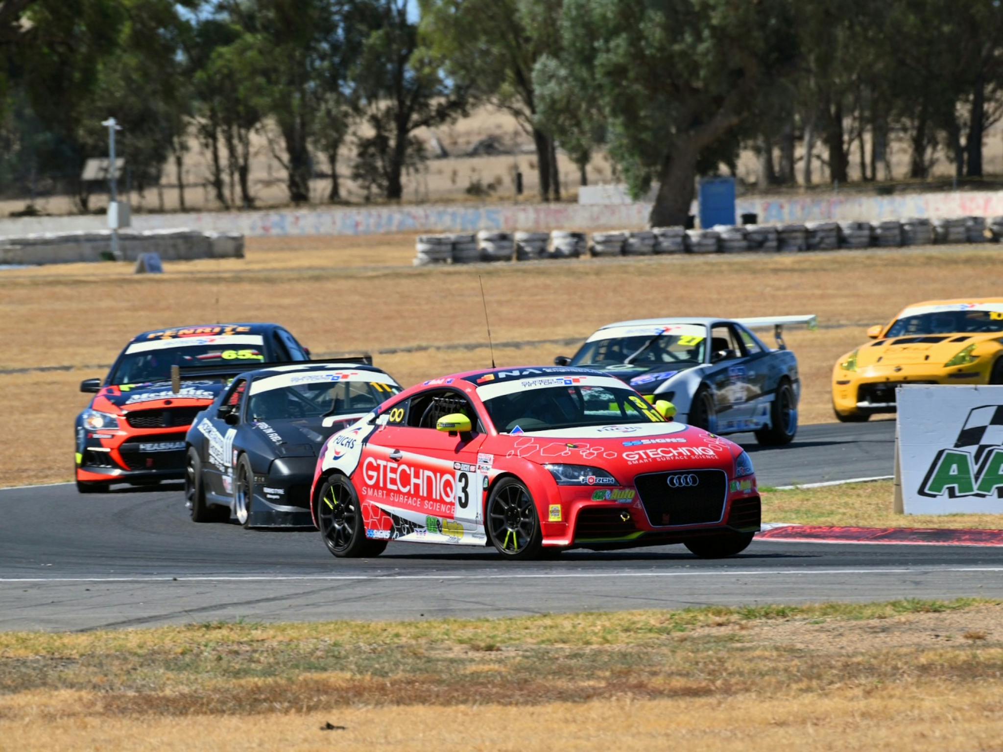 Group of cars racing around Winton Raceway