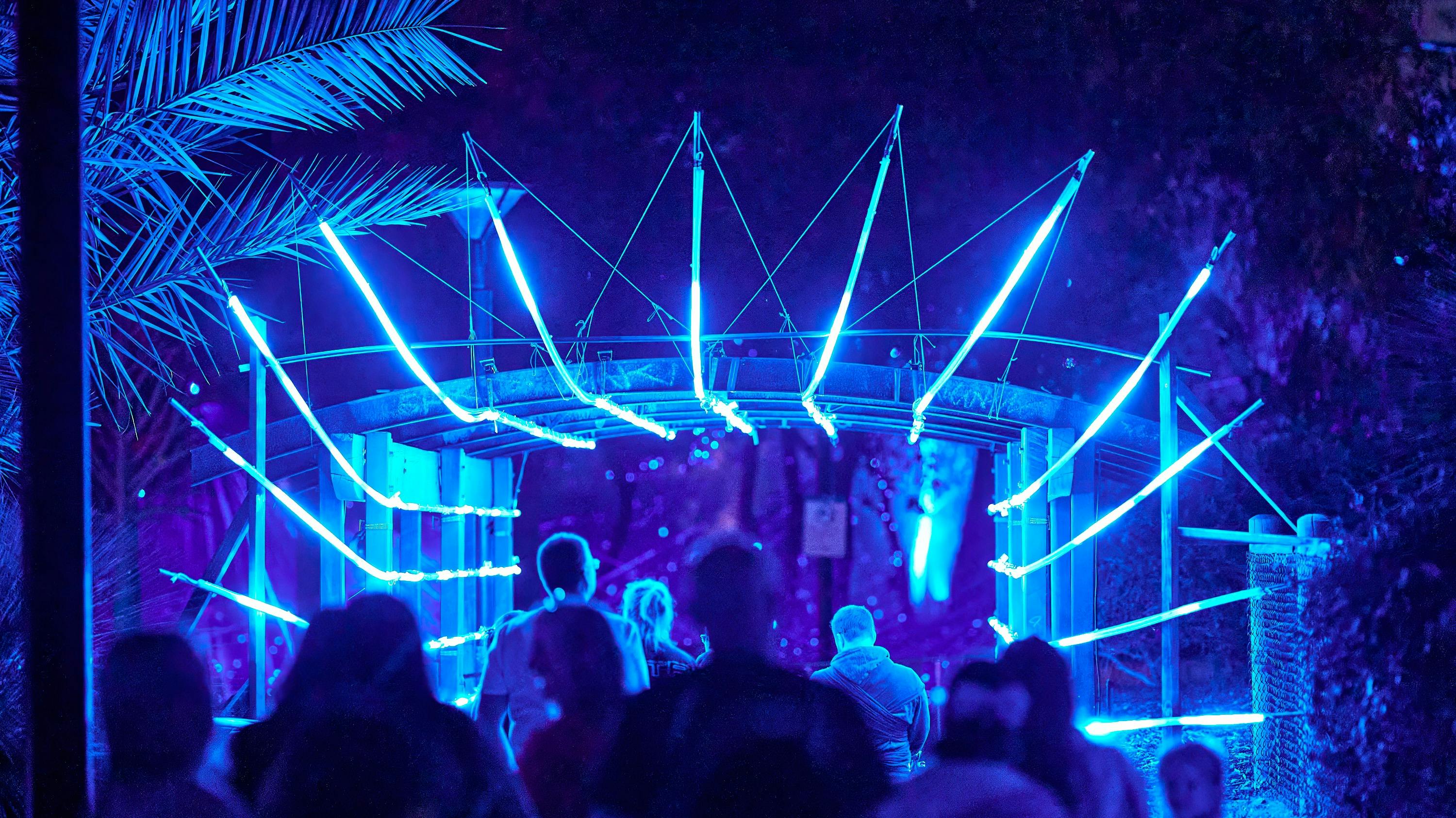 Attendees enter a neon blue portal