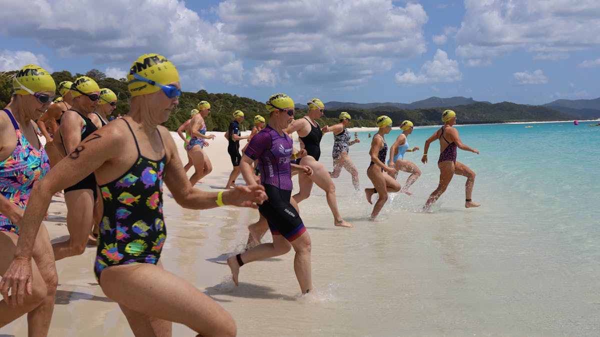 start of race for female swimmers running into the water to begin race