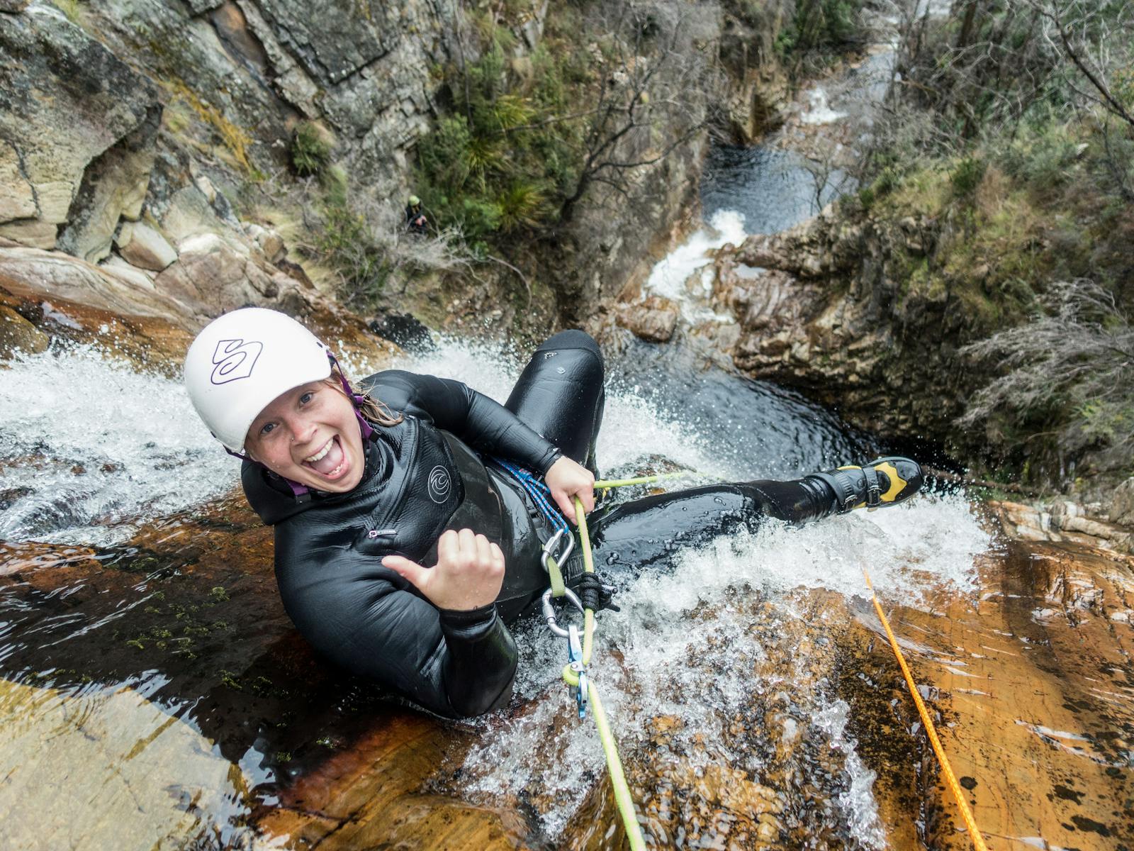 A canyoner about to go over a big waterfall at Cradle Mountain, Tasmania
