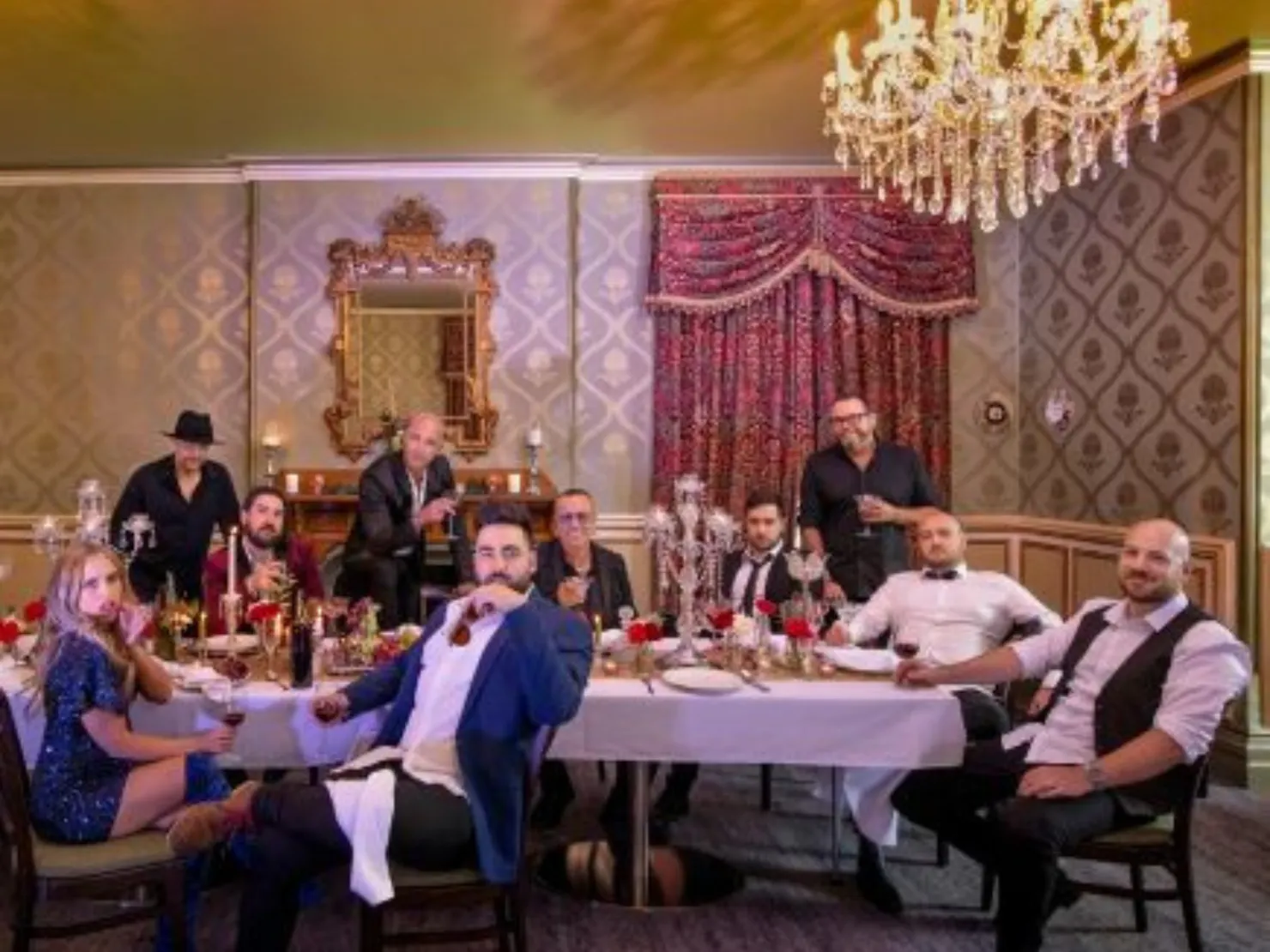 A group singers sitting around a table in a ball room.