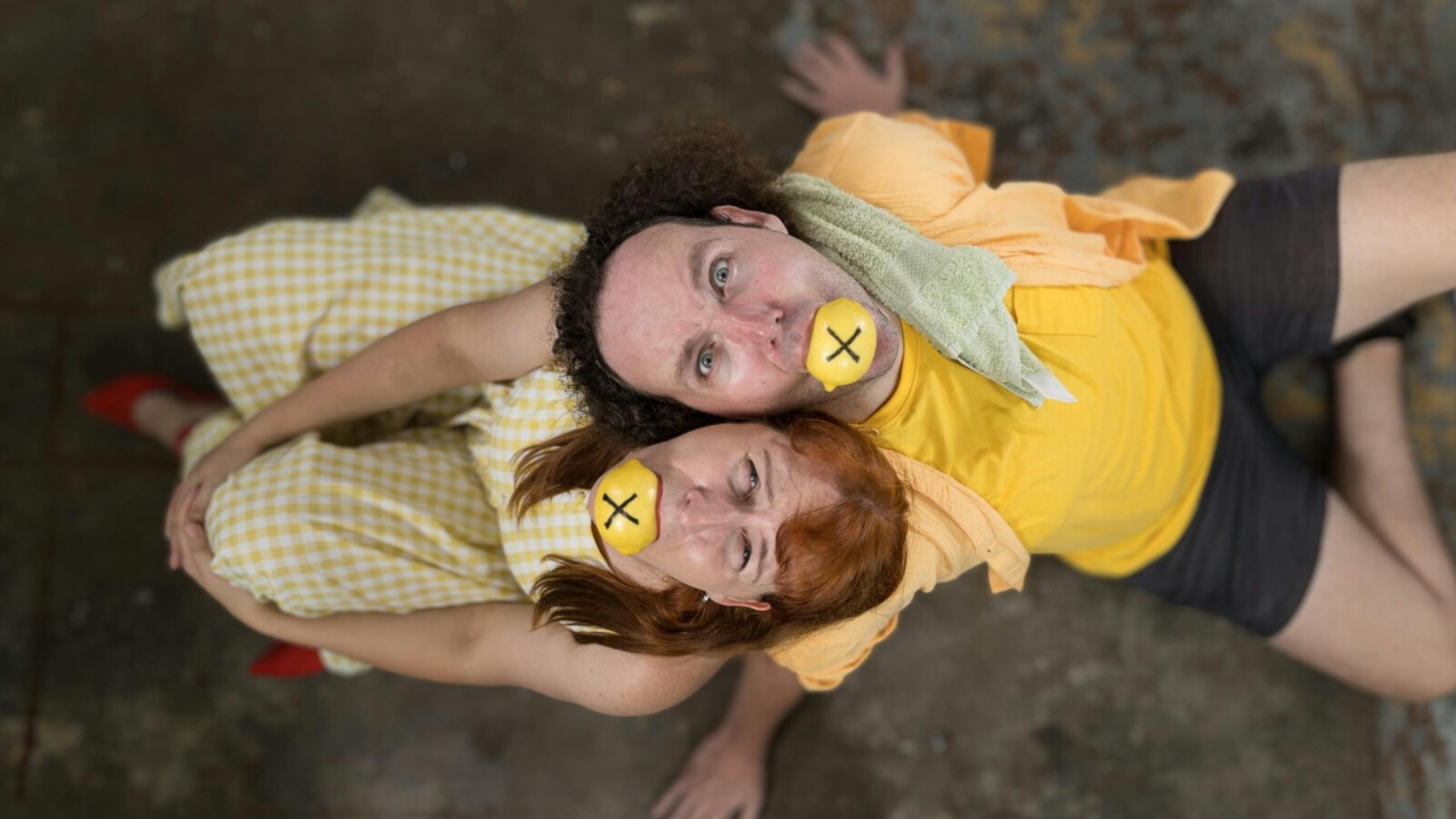 Two people with lemons. The lemons have crosses on them.