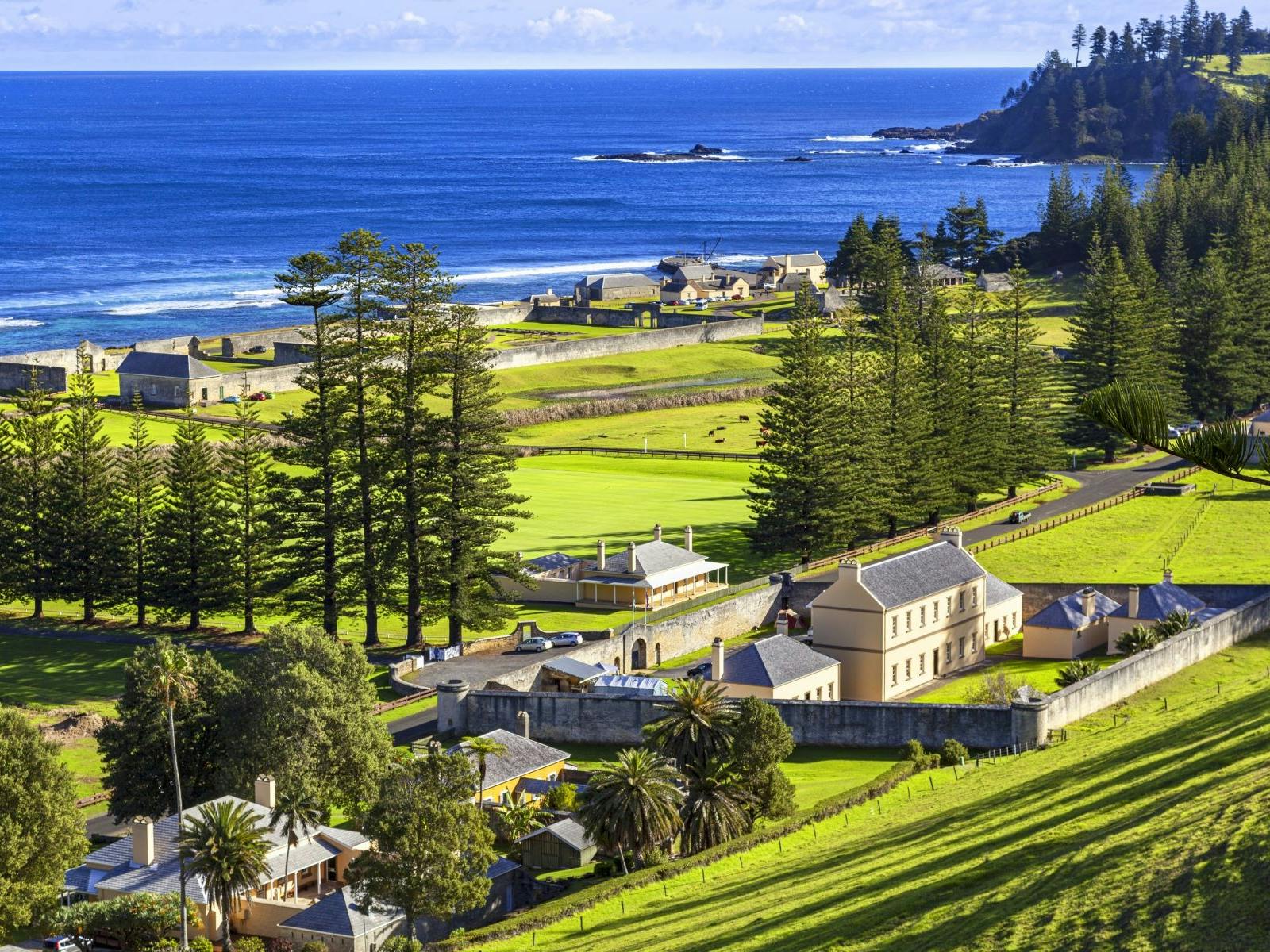 Convict buildings perched on a lush green hill near the ocean Convict buildings perched on a lush green hill near the ocean