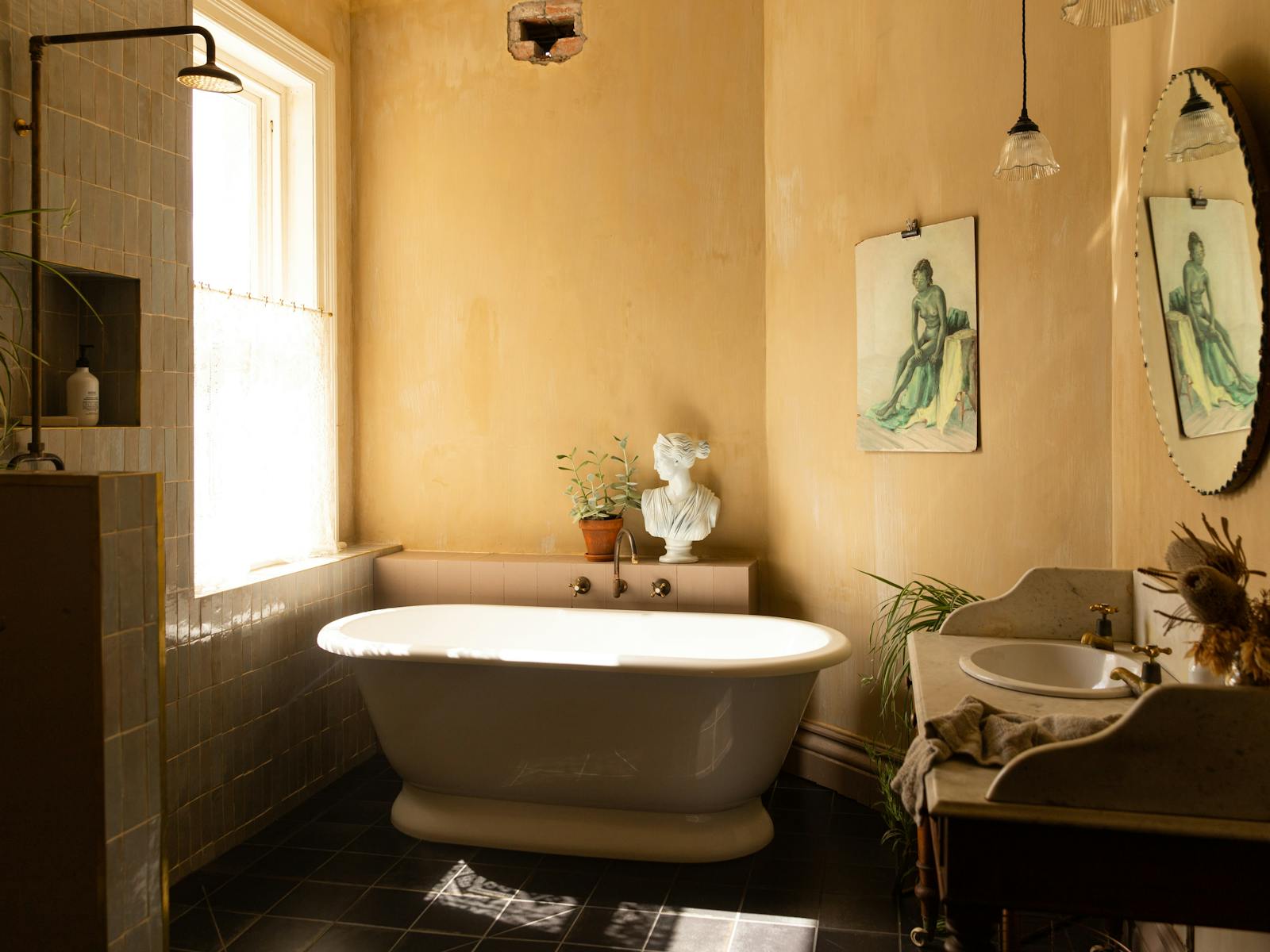 A sunny luxurious bathroom with vintage paintings on the wall