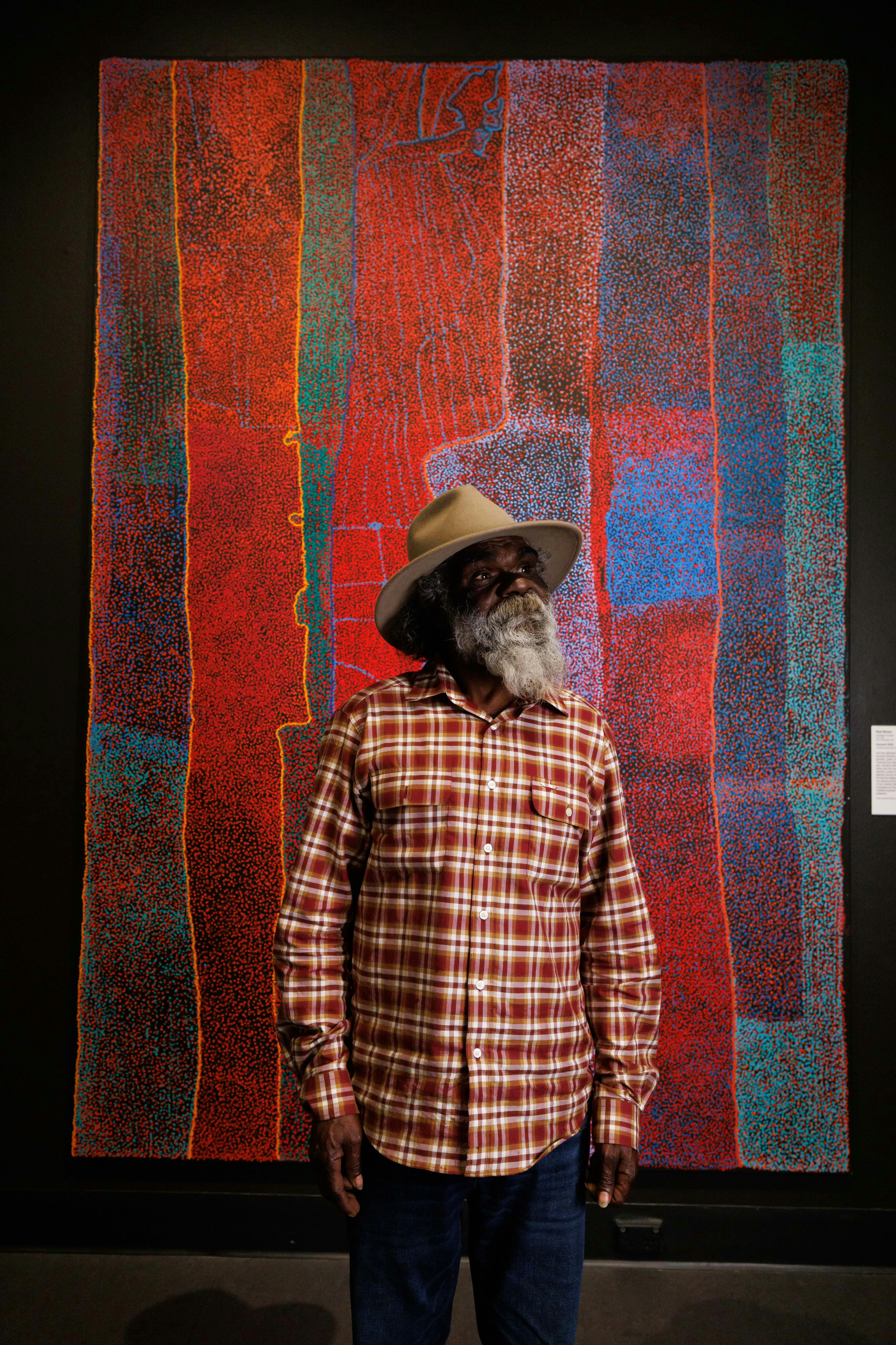 2024 Telstra Art Award Winner Noli Rictor standing in front of his painting Kamanthi 2023