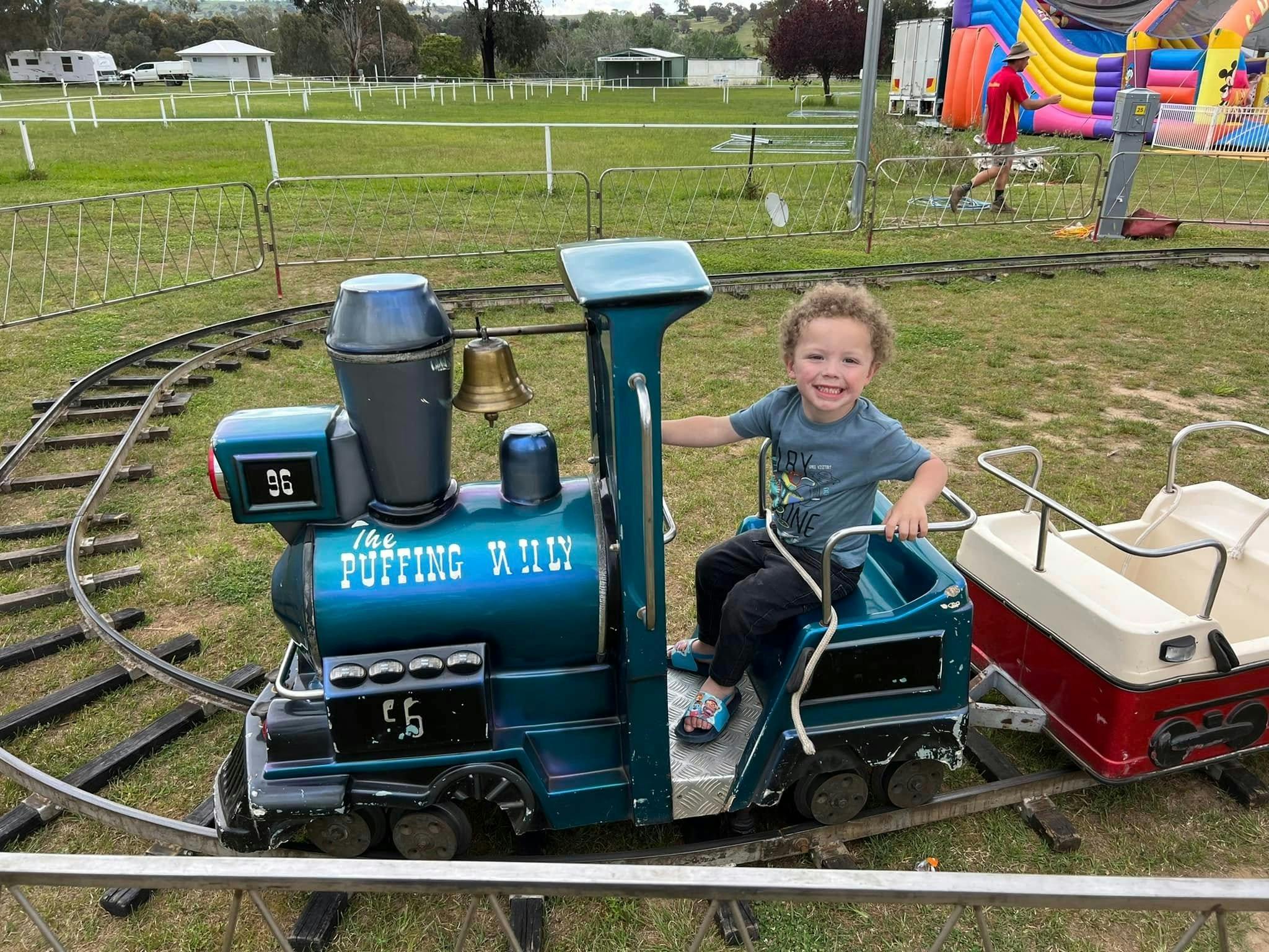 Child riding on a model train