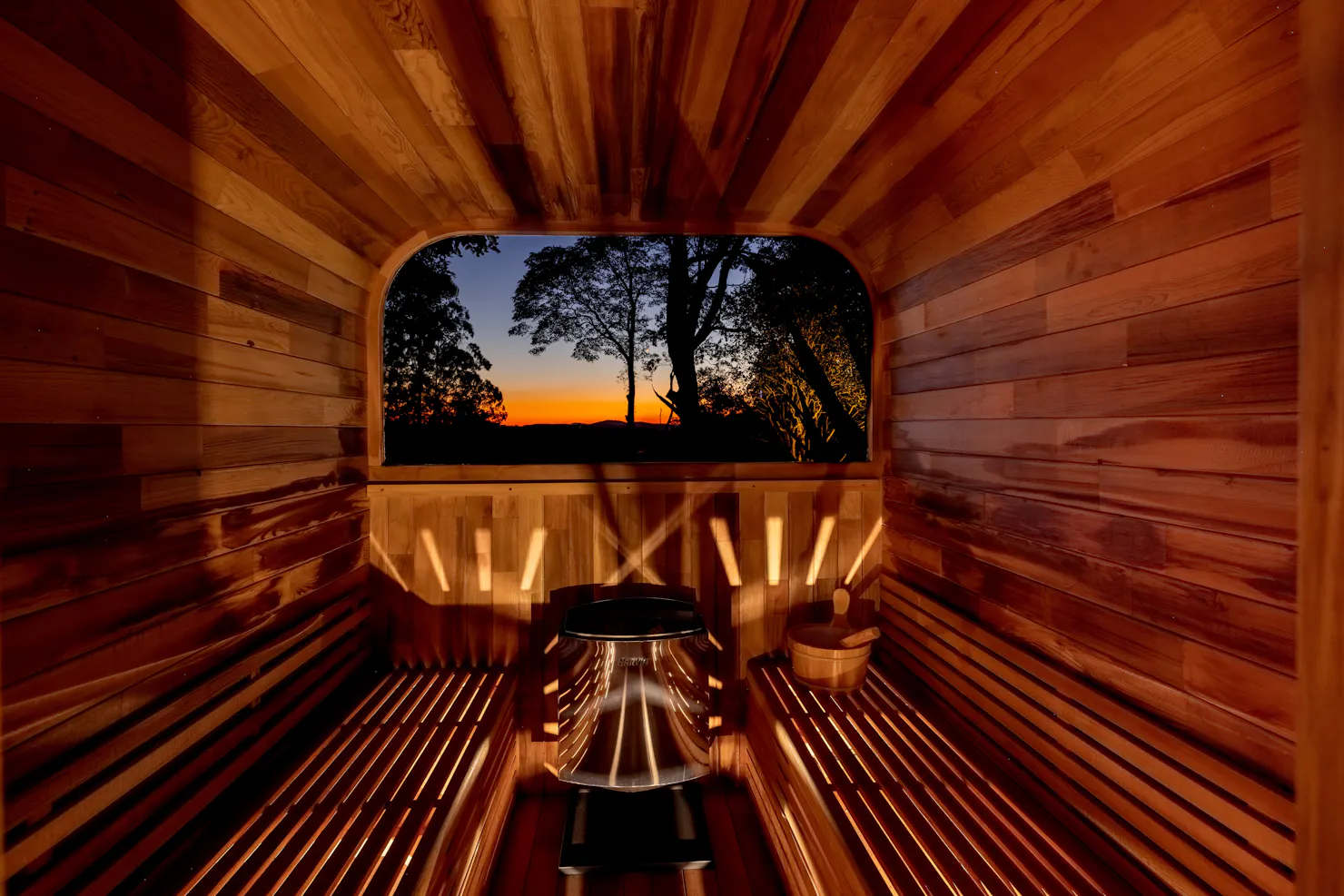 Timber sauna at Hinterland Igloo with a window framing a sunset over the Sunshine Coast Hinterland.