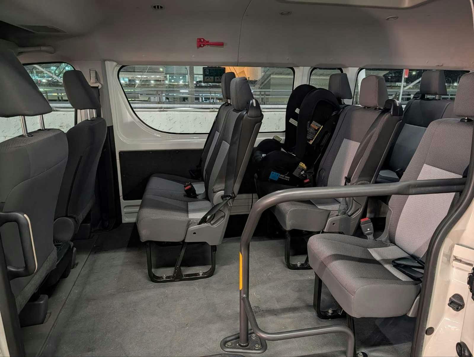 Interior of a Toyota HiAce maxi cab with passenger seating and a fitted child seat