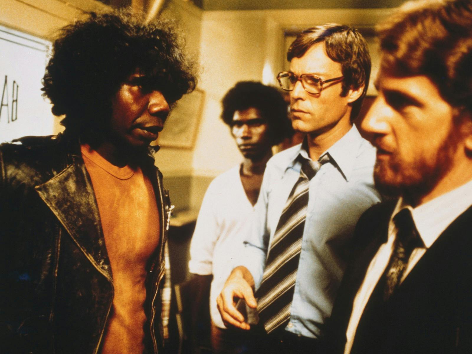 Two Aboriginal men standing next to two white men in an office