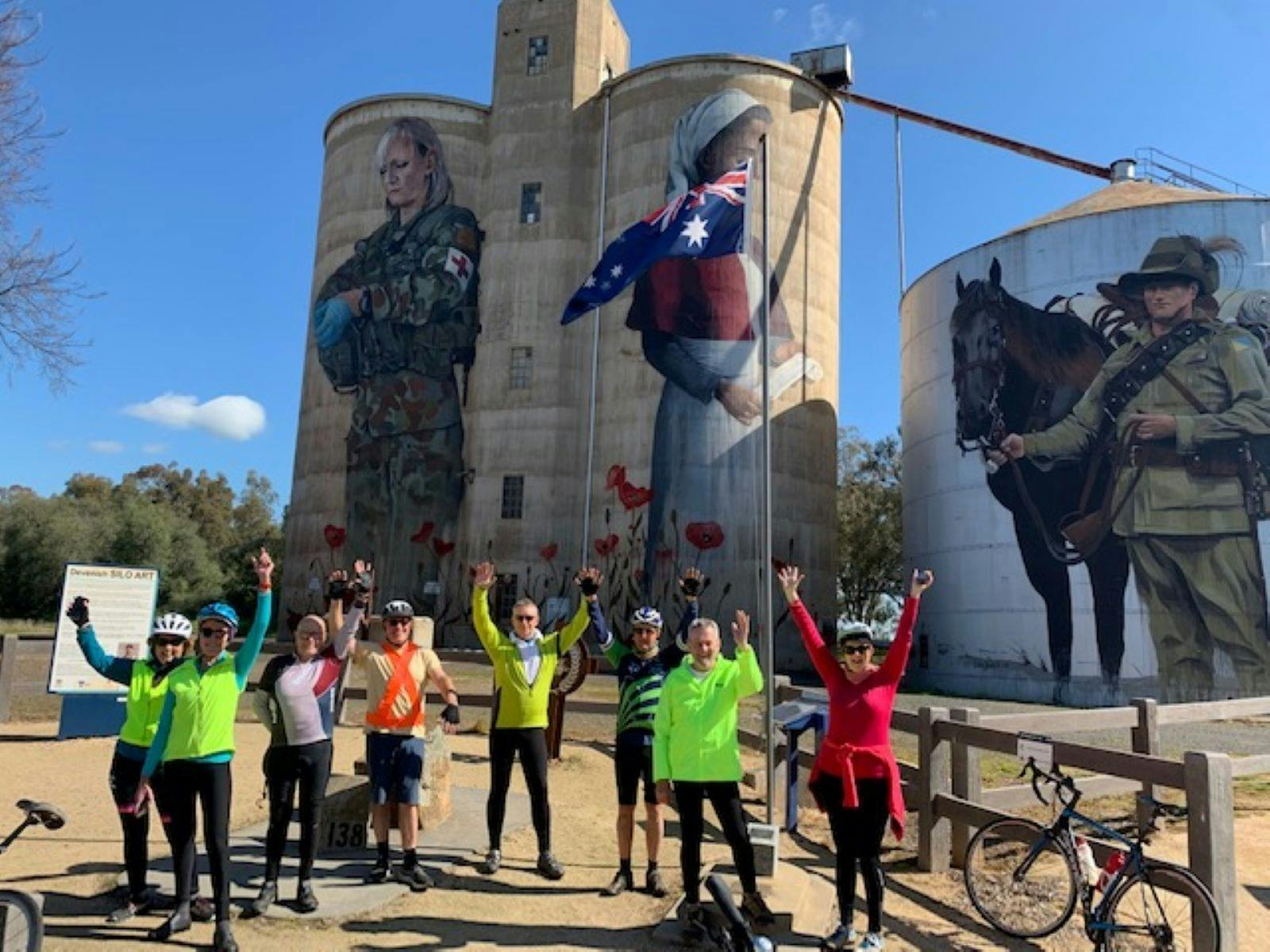 Cyclists in front of silo art