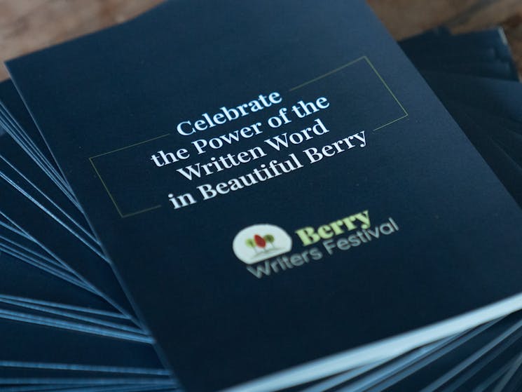 Charcoal pamphlet  with 'Celebrate the power of the written word in beautiful Berry' written