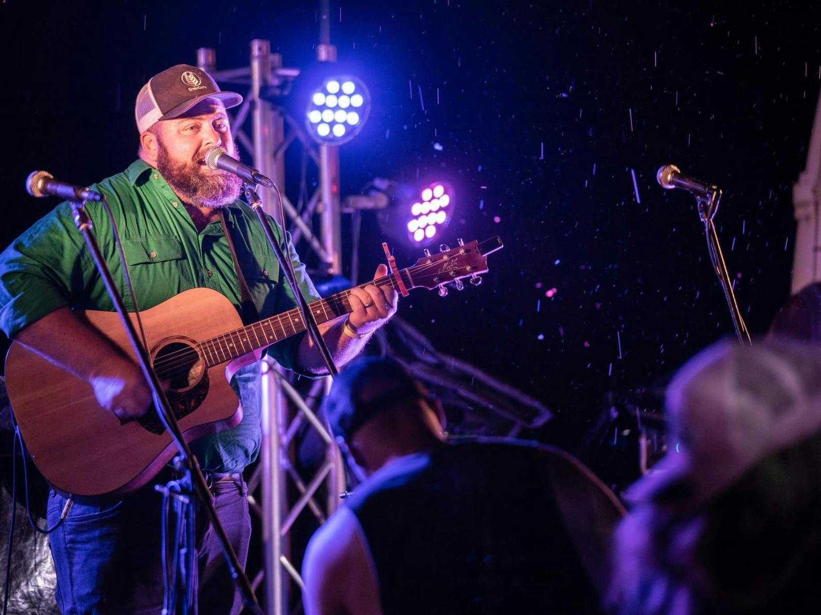 Man singing and playing guitar on stage at the Longyard