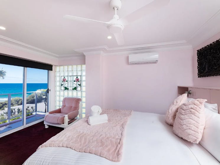 Bedroom with stunning ocean views, TV, air-conditioning and ceiling fan
