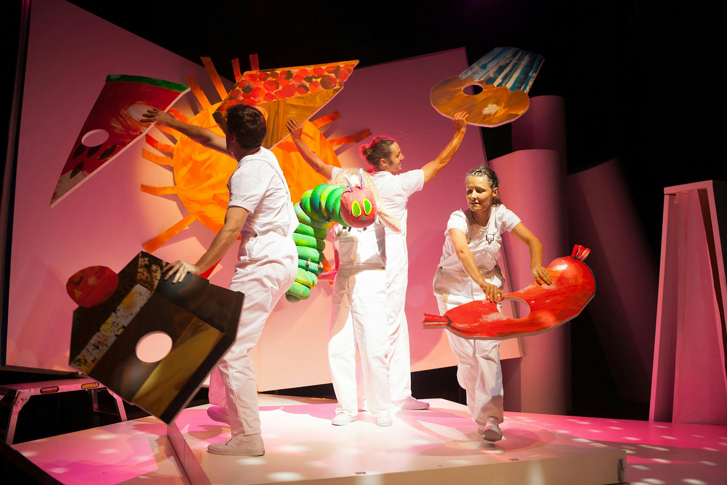 Stage production image of the children book. Four people olding cutout images of food.