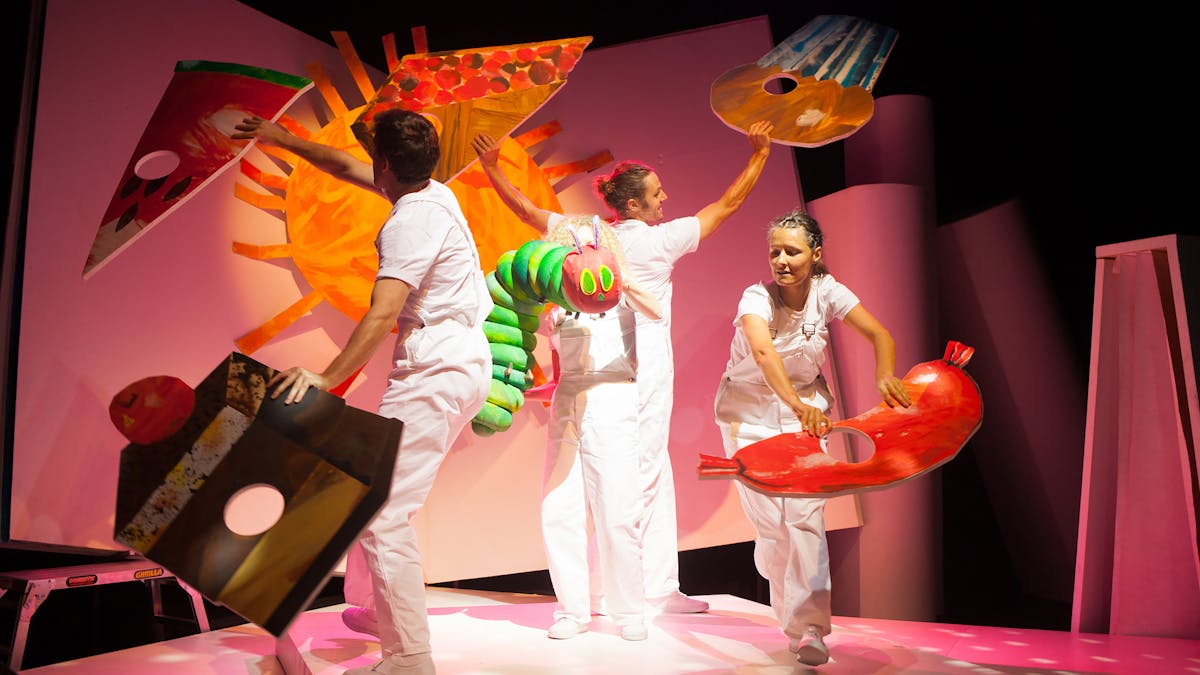 Stage production image of the children book. Four people olding cutout images of food.