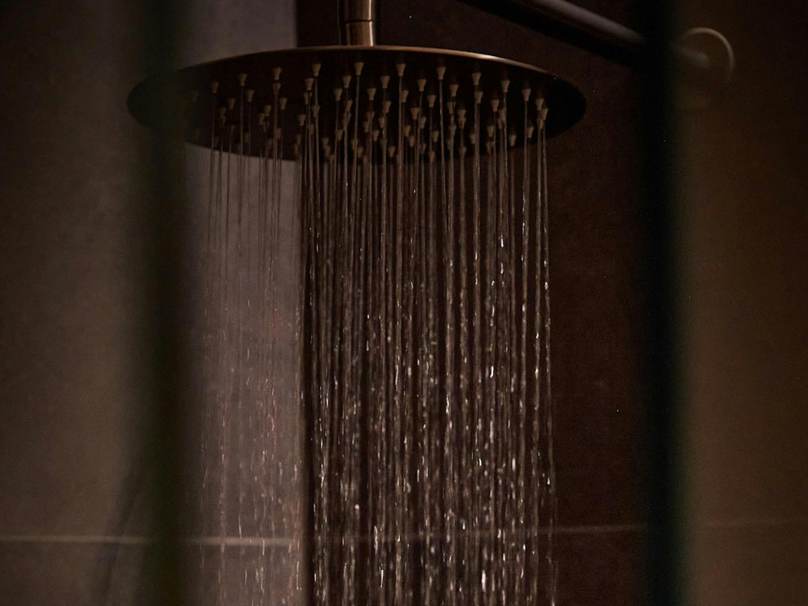 Picture of rainfall shower head with water streaming out.