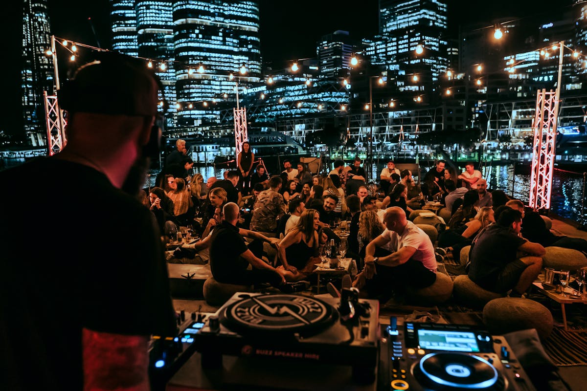 DJ Shot from behind of guests in foreground and Barangaroo panorama