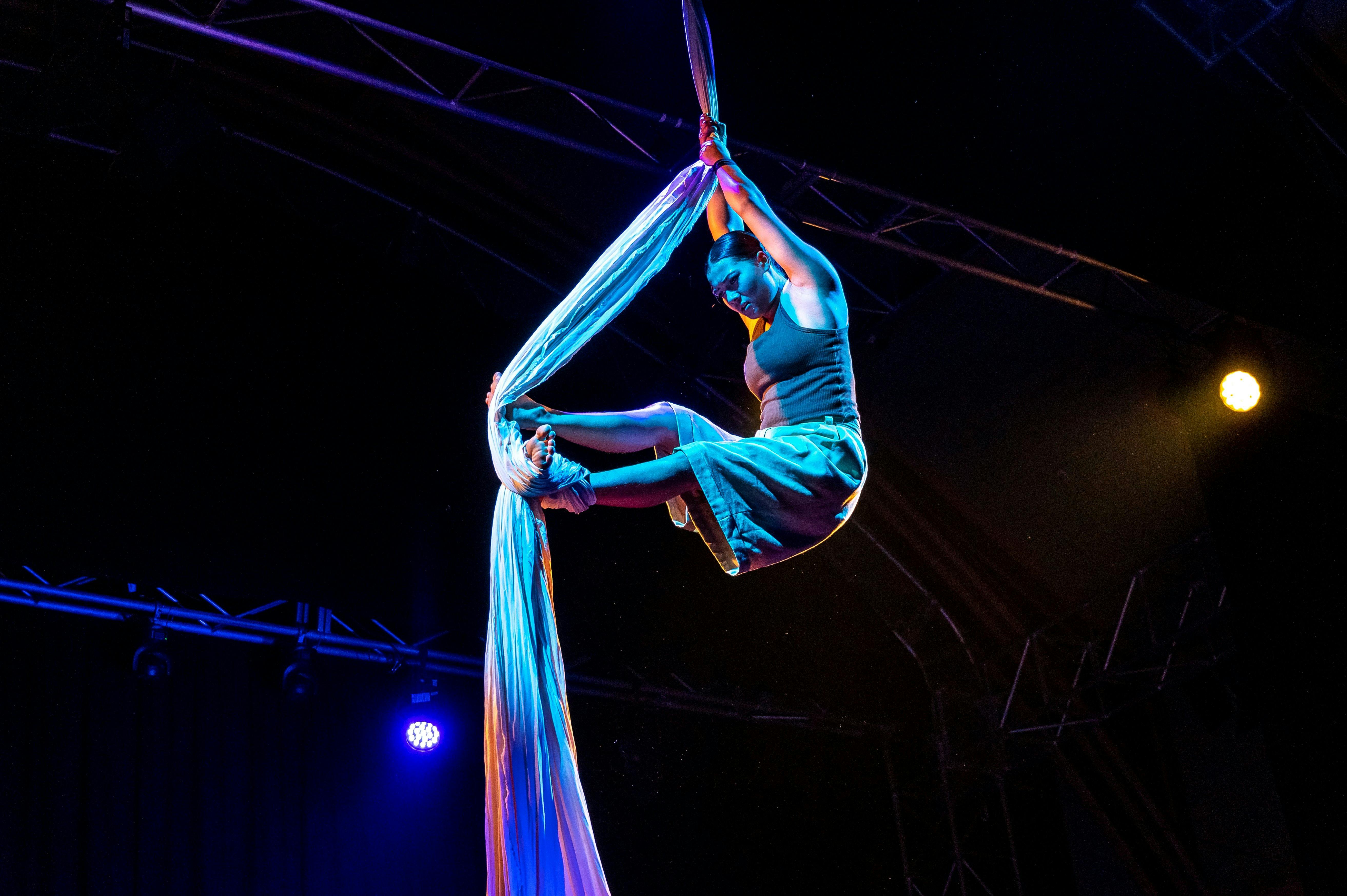 Suspended performer, climbing a stream of cloth