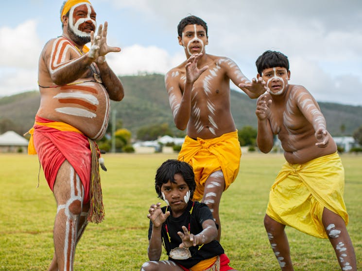 Four young male Aboriginal dancers in cultural dress posing for the camera
