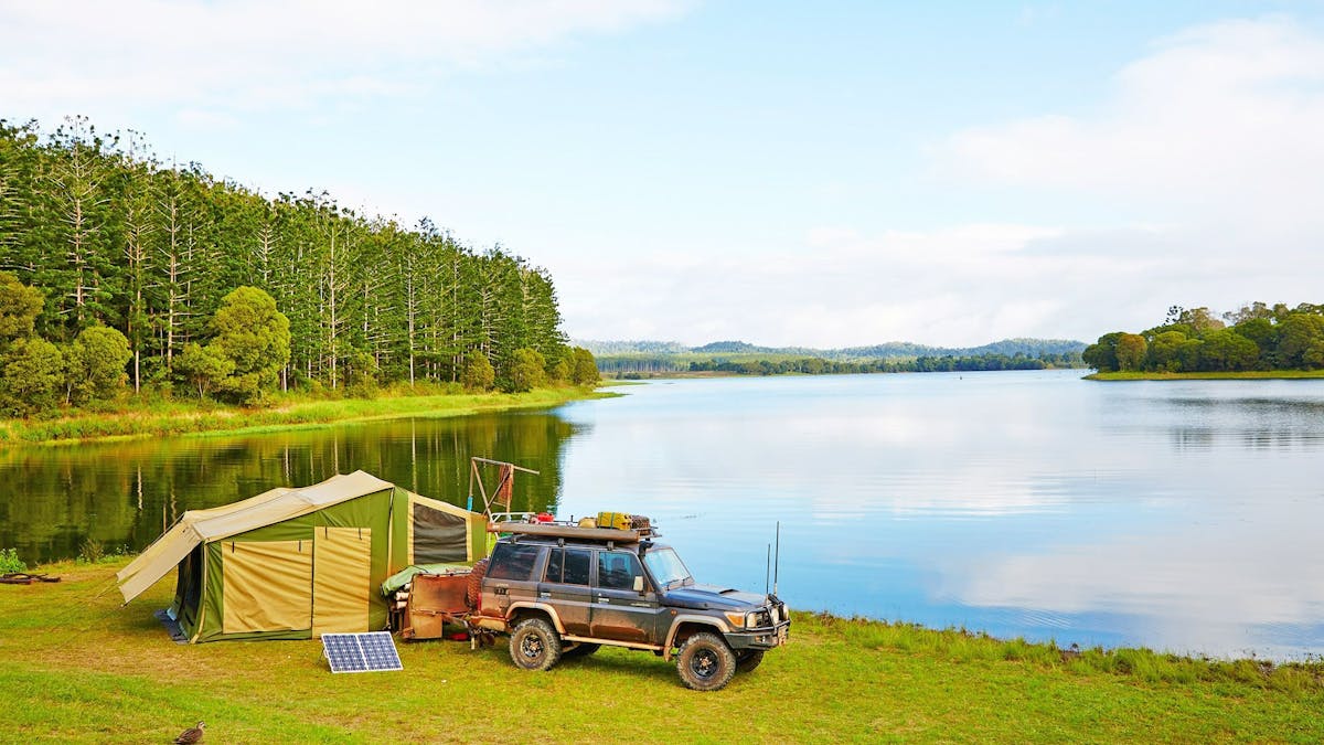 Four-wheel-drive vehicle and tent set up on the banks of Lake Tinaroo Four-wheel-drive vehicle and tent set up on the banks of Lake Tinaroo