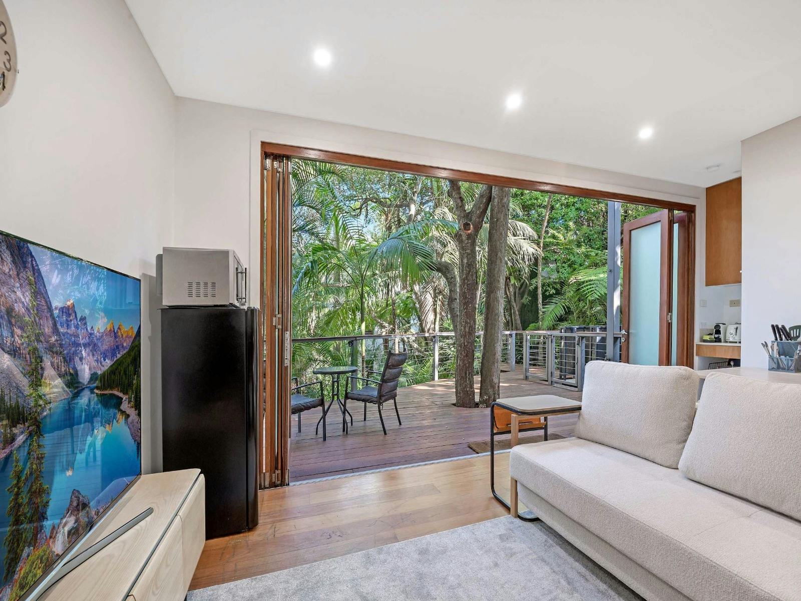 Living room with sofa, TV, and large sliding doors opening to the balcony.