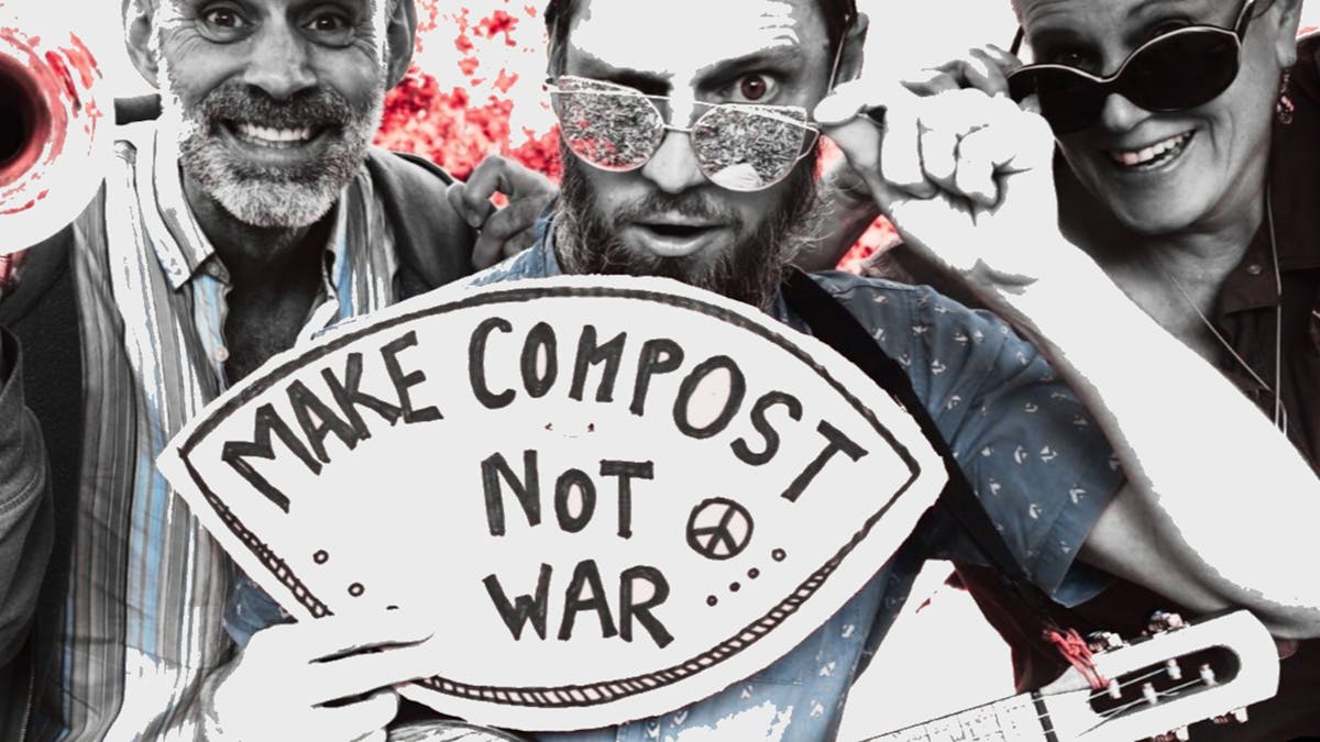 Formidable Vegetable hold a sign that says "make compost not war"