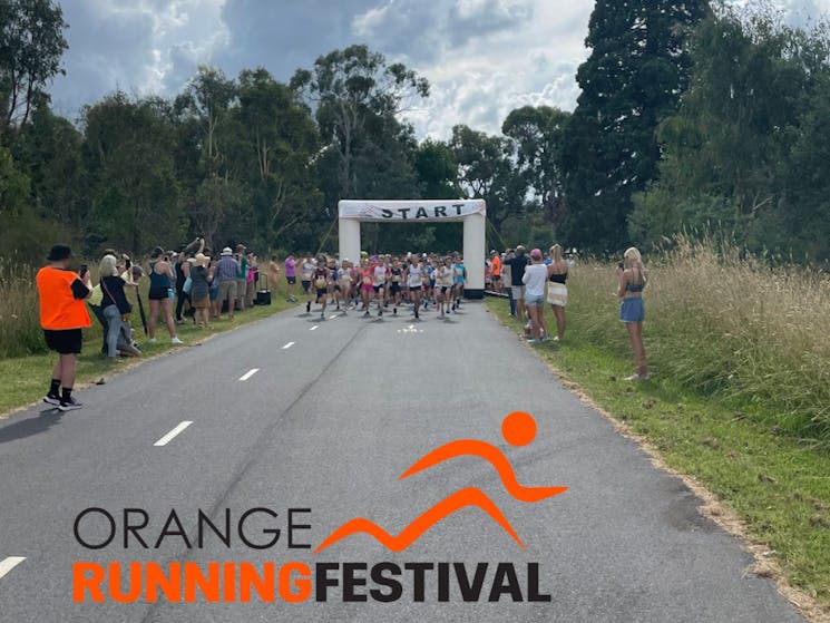 Runners passing under the starting banner of the Orange Running Festival