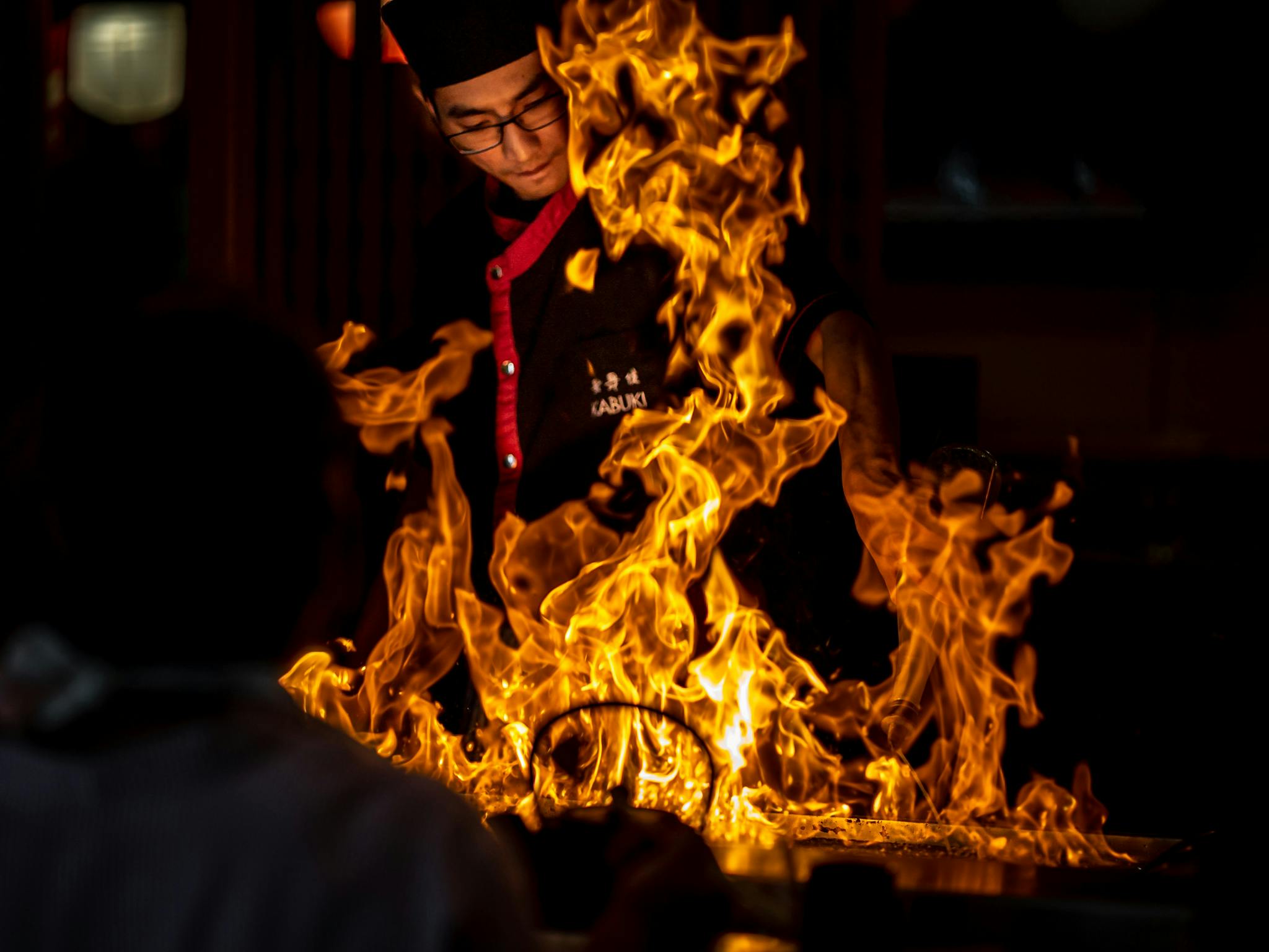 Teppanyaki chef behind a flame on a grill Teppanyaki chef behind a flame on a grill