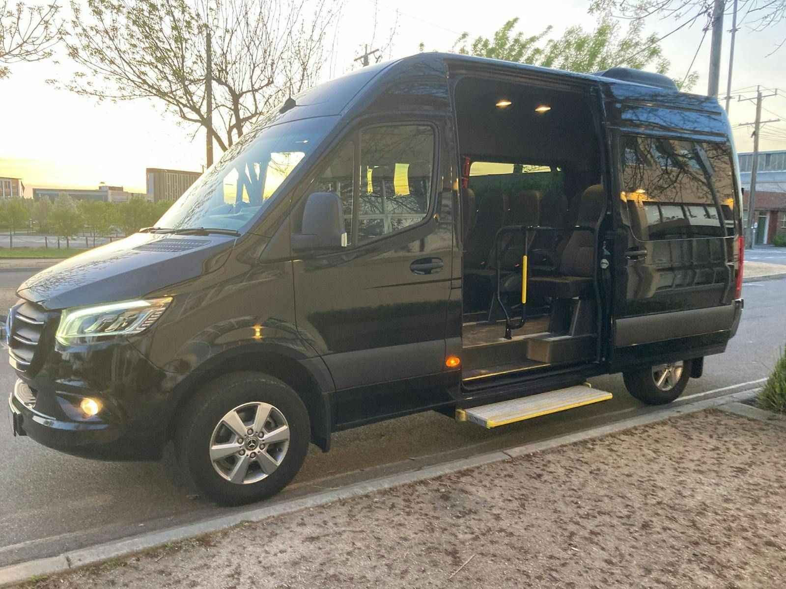 Black Mercedes Sprinter chauffeur van with passenger step — group airport transfers NSW