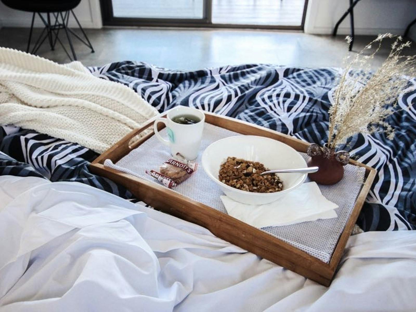 a bed with breakfast on a tray
