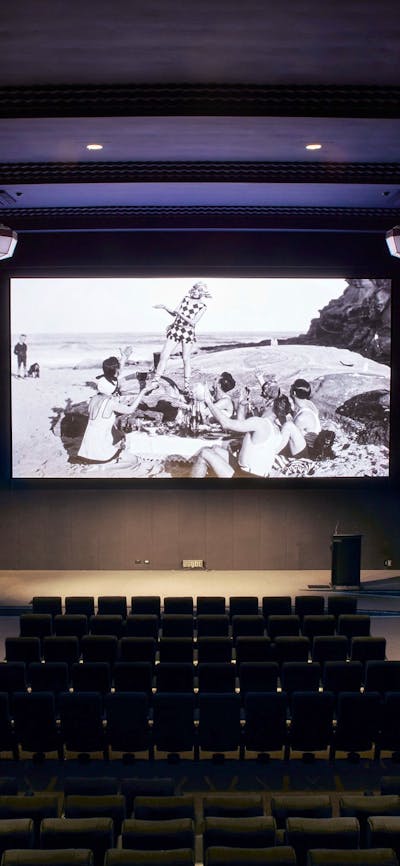 Arc Cinema with archival black and white footage on the screen
