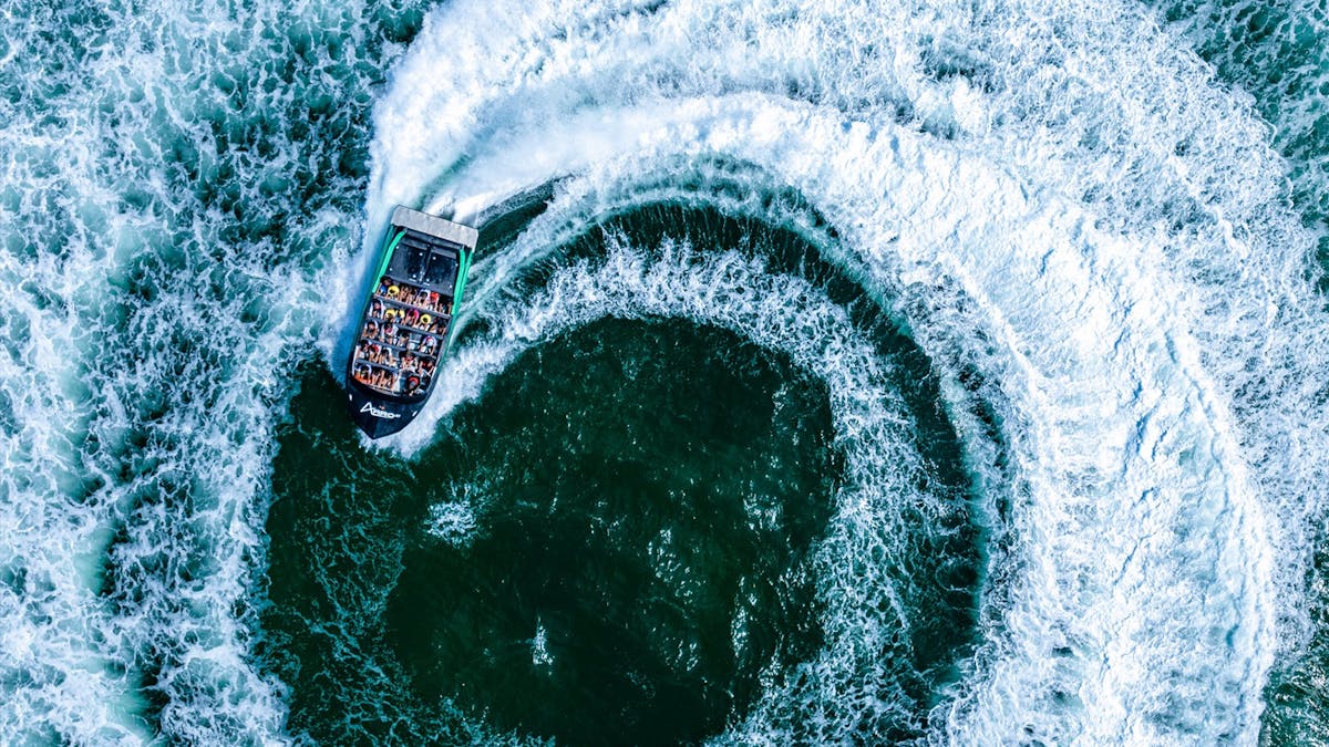 Aerial view of Arro Jet Boat doing a spin with white wash everywhere.