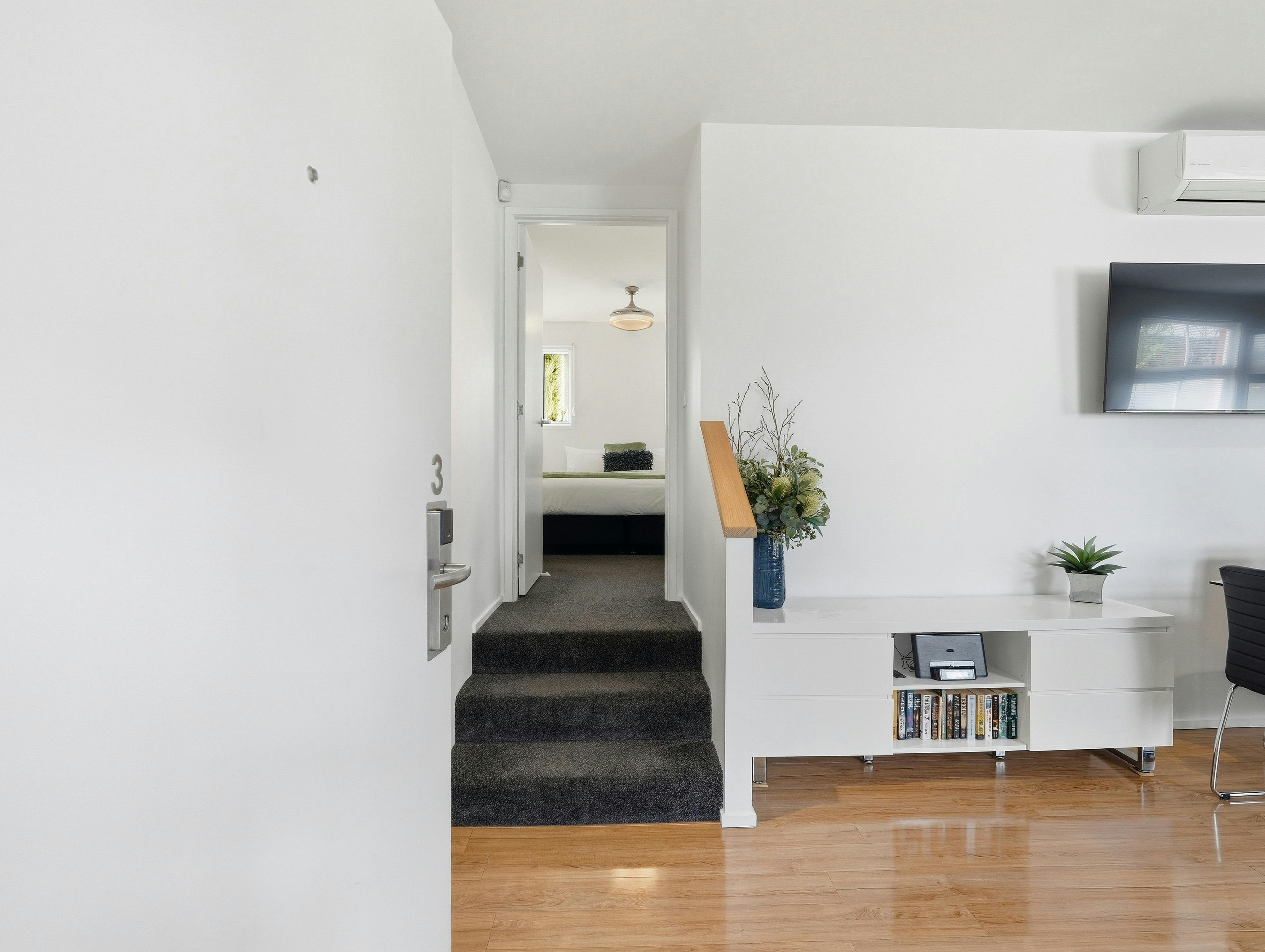 Apartment entrance with stairs leading to the main bedroom and ensuite