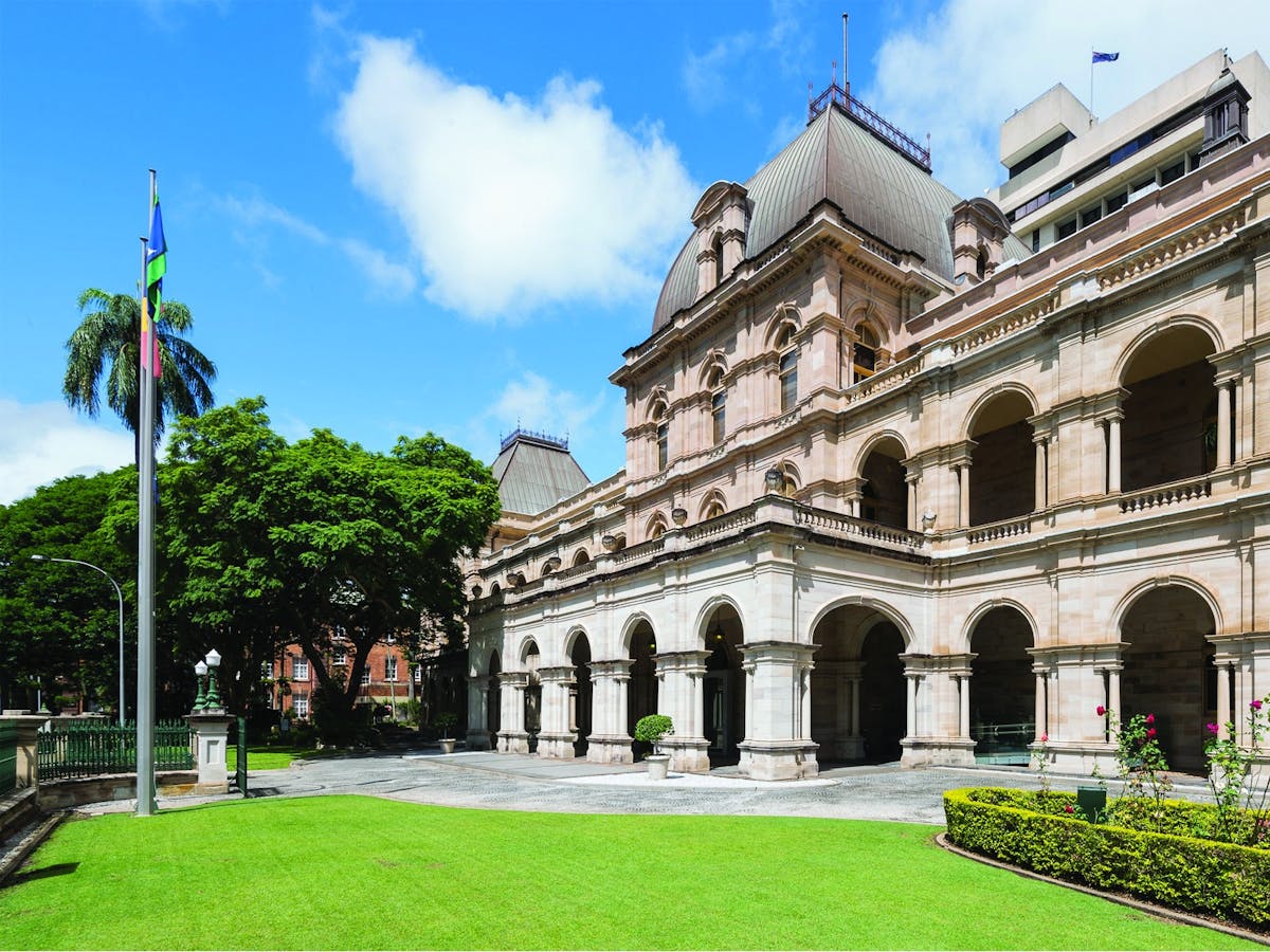 A sunny, wide shot of the Queensland Parliament House in Brisbane, Australia.