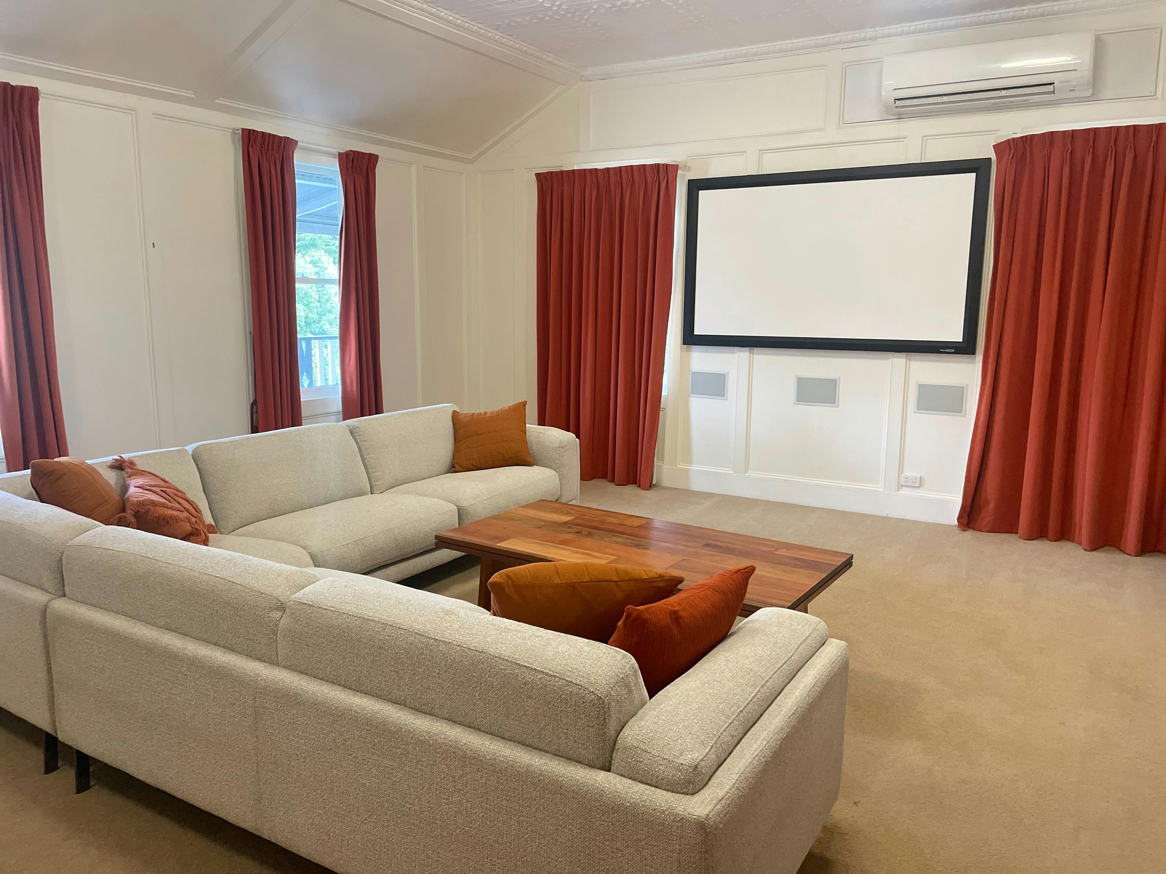 large lounge room with 8 seat l shaped lounge, projector & screen for movies