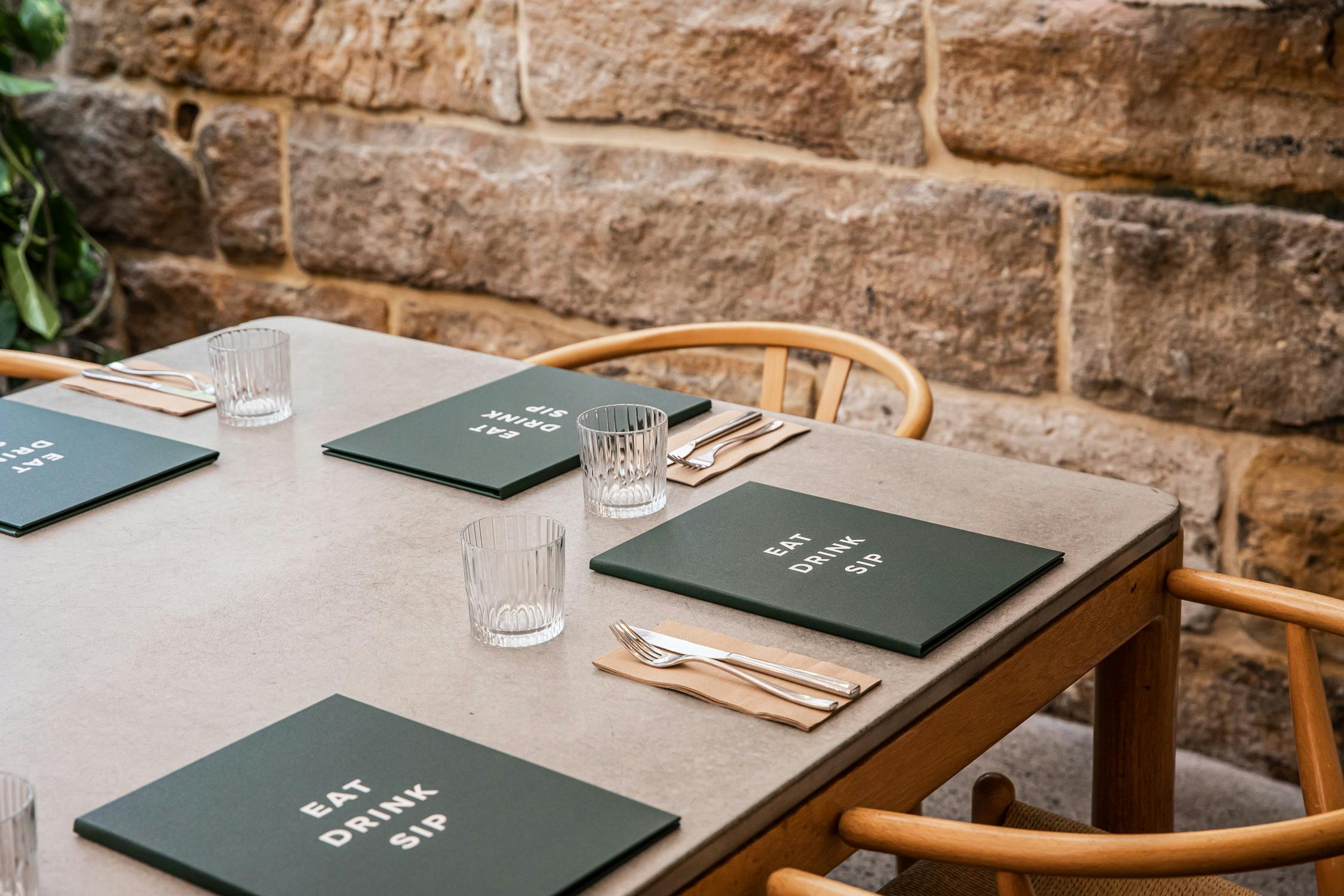 Menus on table with sandstone wall in the background