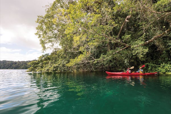 Two kayakers paddling on Lake Barrine